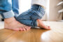 Small child and parent barefoot on hardwood flooring material. Featured image for flooring materials blog.